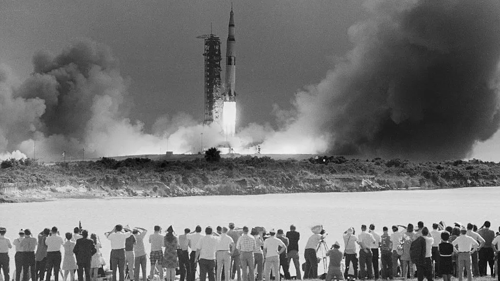 The image displays the launch of NASA's Moon rocket, the Saturn 5, during the 1960s